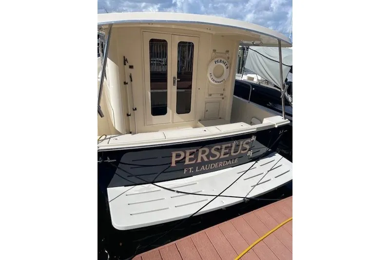 Slide: The Image of 2008 Mainship 34 Trawler Hardtop docked at a marina with urban backdrop. - 1
