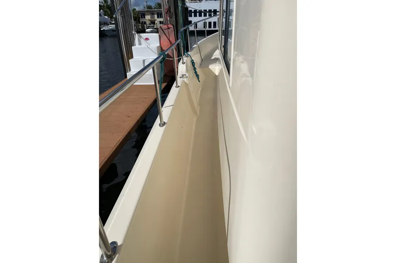 Slide: The Image of Bow of 2008 Mainship 34 Trawler Hardtop at marina, with water and boats in background. - 10