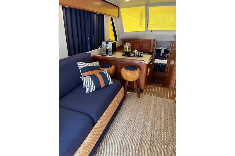 Slide: The Image of Interior of 2008 Mainship 34 Trawler Hardtop with blue seating and wooden accents. - 14