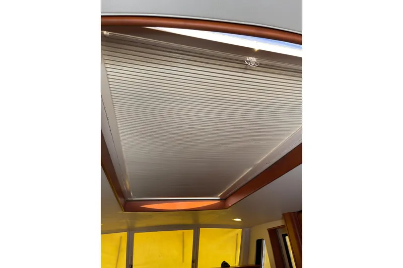 Slide: The Image of 2008 Mainship 34 Trawler Hardtop helm with navigation instruments and wooden steering wheel. - 22