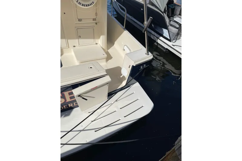 Slide: The Image of 2008 Mainship 34 Trawler Hardtop docked near yellow building with palm trees. - 6