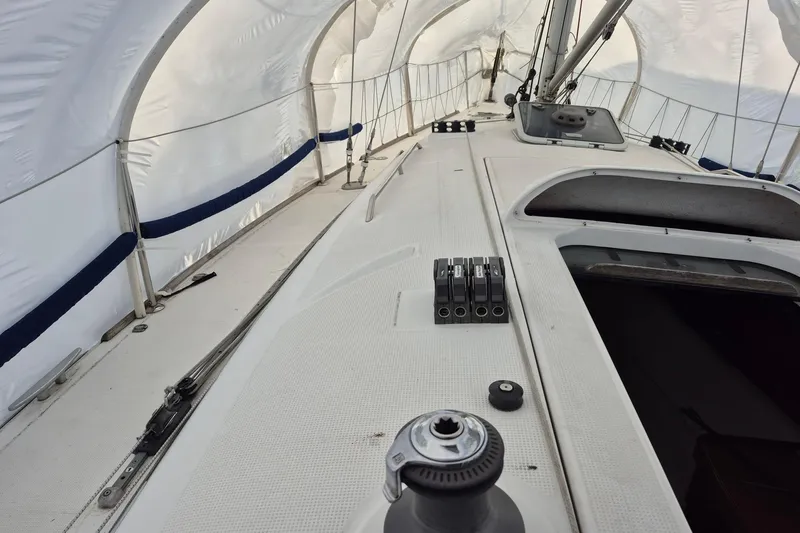 Slide: The Image of 2003 Beneteau First 36.7 sailboat deck under protective cover, showcasing winches and rigging. - 10