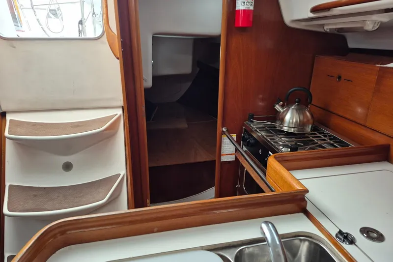 Slide: The Image of Interior of 2003 Beneteau First 36.7 sailboat with wooden finish and white seating. - 17