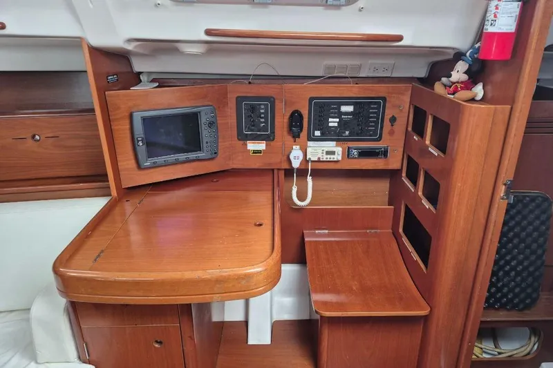 Slide: The Image of 2003 Beneteau First 36.7 yacht interior with navigation equipment and wooden cabinetry. - 24