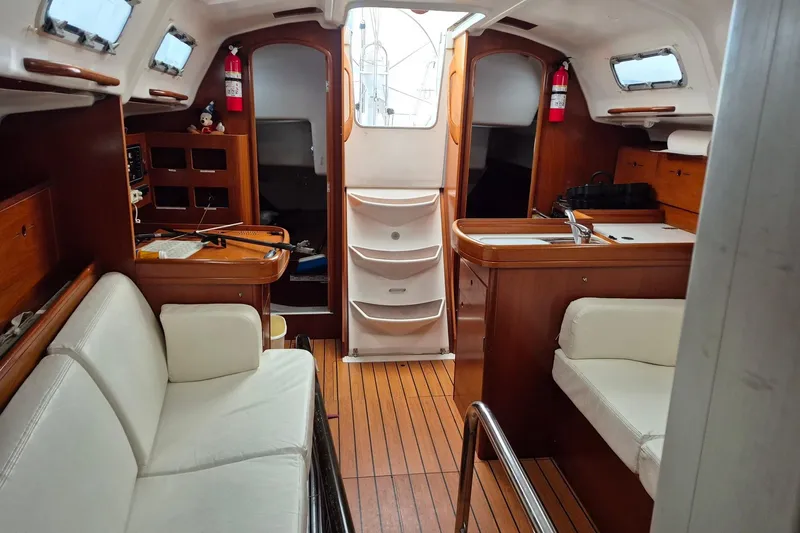 Slide: The Image of Interior of 2003 Beneteau First 36.7 sailboat with wood finish and white seating. - 25