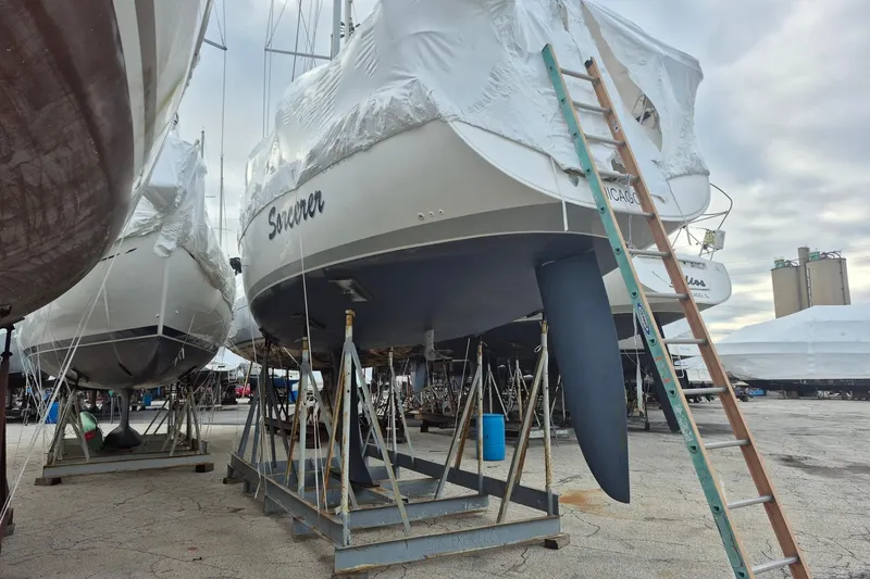 Slide: The Image of 2003 Beneteau First 36.7 sailboat in dry dock, covered and supported by stands. - 5