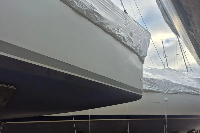 Slide: The Image of 2003 Beneteau First 36.7 sailboats covered in protective wrap, docked side by side. - 7