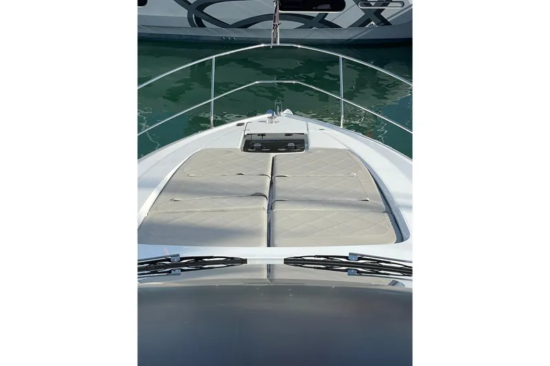 Slide: The Image of 2025 Fairline Squadron 50 yacht bow with sunbathing cushions, docked in marina. - 15