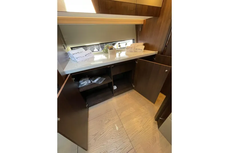 Slide: The Image of Interior of 2025 Fairline Squadron 50 yacht with open wooden cabinets and countertop. - 27