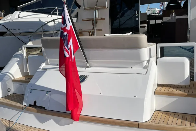 Slide: The Image of 2025 Fairline Squadron 50 yacht with red flag, elegant deck, and modern design. - 9