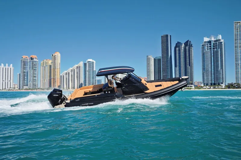 Slide: The Image of Ranieri CAYMAN 38.0 EXECUTIVE 2025 cruising near city skyline. - 0