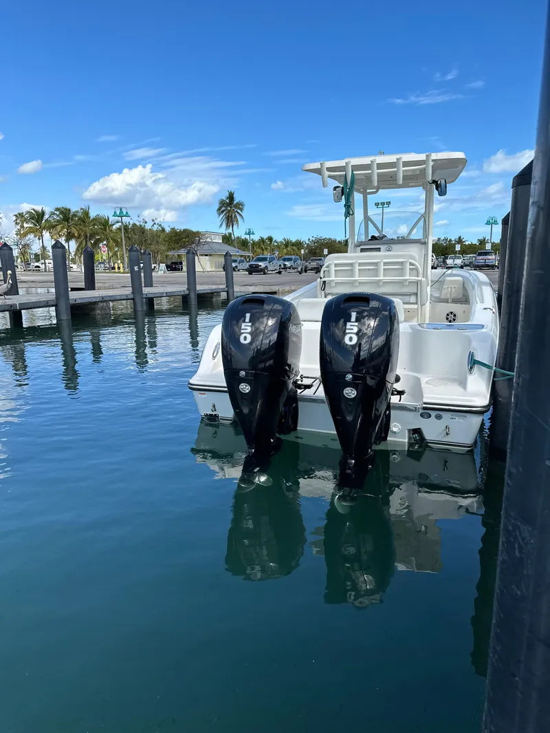 Slide: The Image of 2020 Mako 236 CC boat docked with dual 150 horsepower engines, clear blue sky. - 10