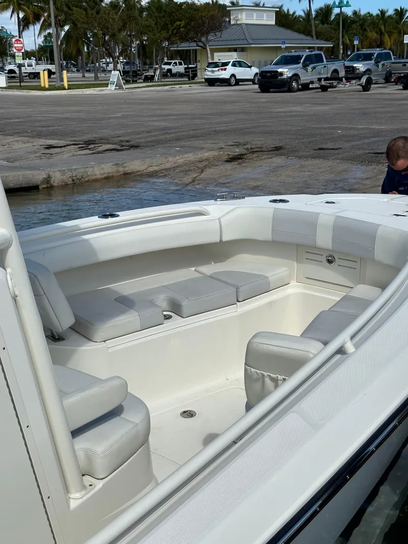 Slide: The Image of 2020 Mako 236 CC boat interior with white seating at a dock. - 14