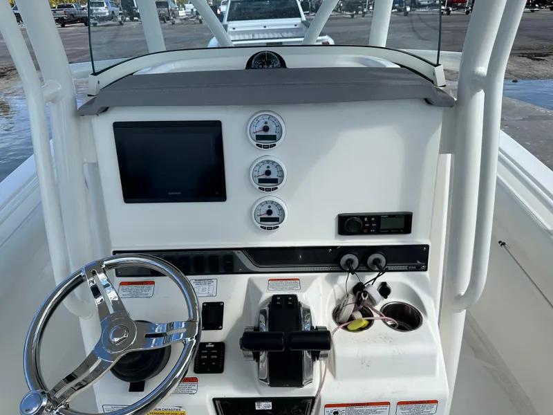 Slide: The Image of 2020 Mako 236 CC boat dashboard with steering wheel, gauges, and controls. - 15