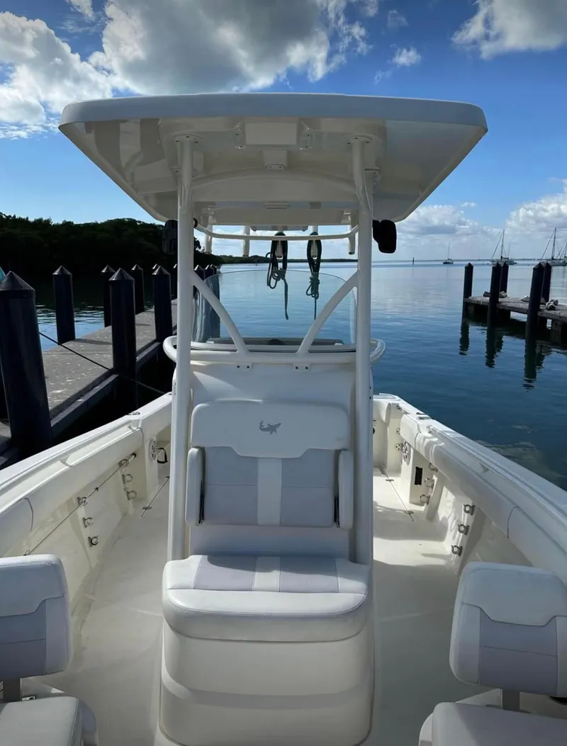 Slide: The Image of 2020 Mako 236 CC boat docked, clear sky, calm water, and scenic view. - 16