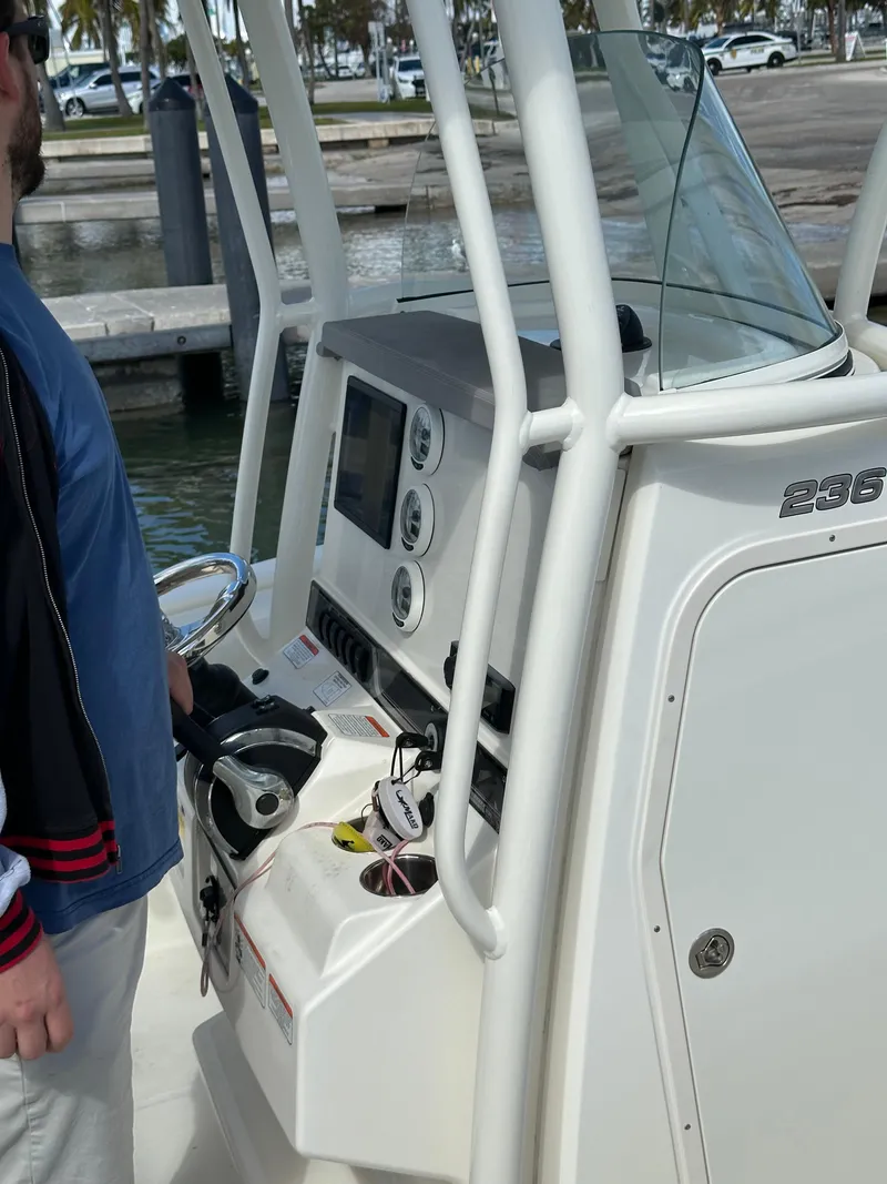 Slide: The Image of 2020 Mako 236 CC boat console with steering wheel and controls at dock. - 17