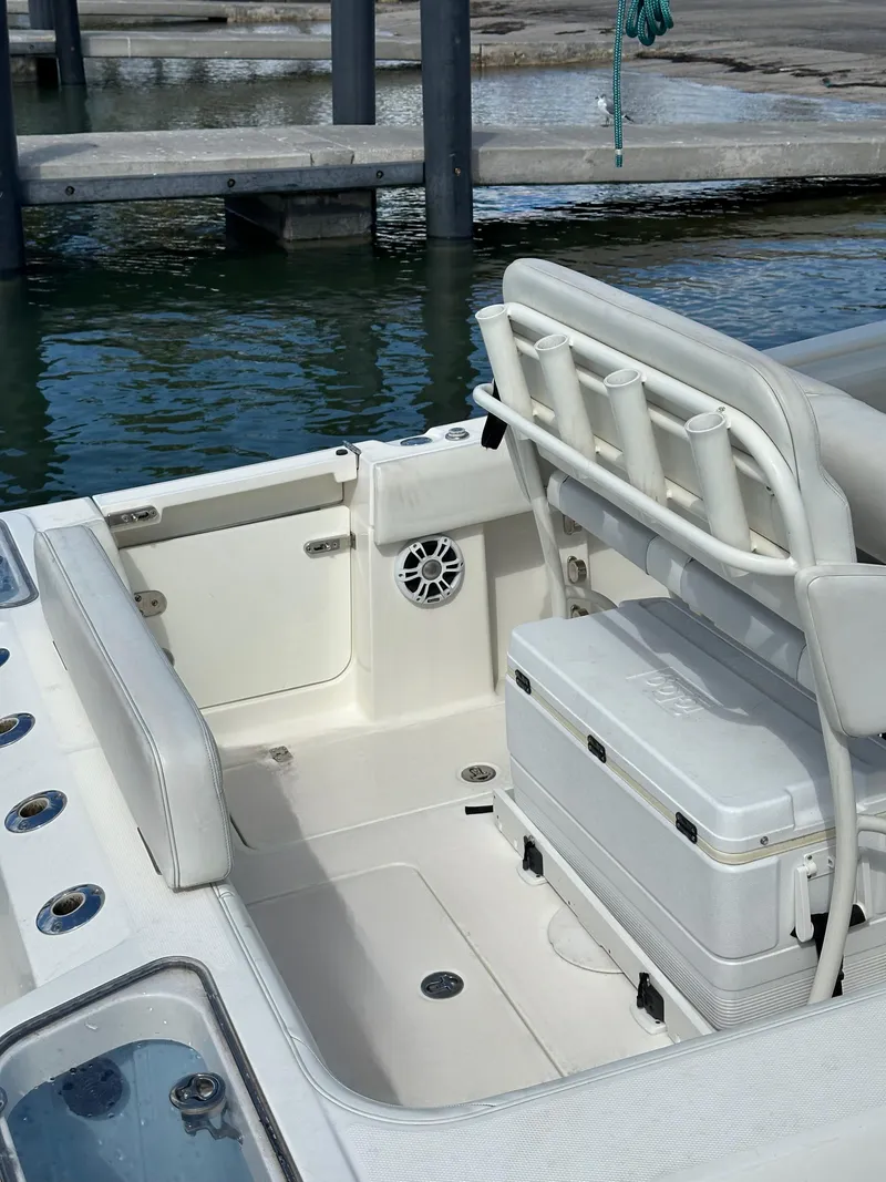 Slide: The Image of 2020 Mako 236 CC boat interior with seating and storage at a marina. - 20