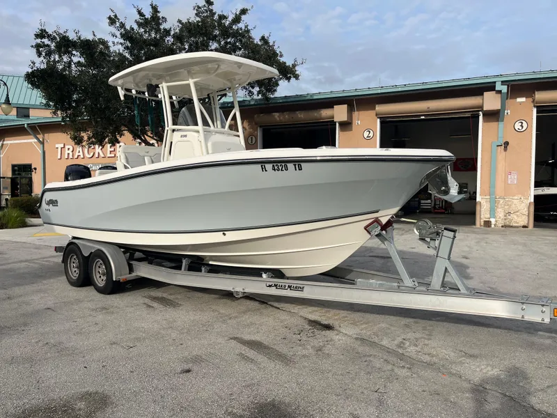 Slide: The Image of 2020 Mako 236 CC boat on trailer, parked outside a building. - 25