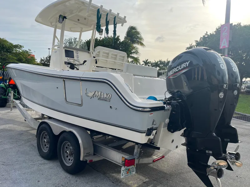 Slide: The Image of 2020 Mako 236 CC boat on trailer with dual Mercury engines, parked outdoors. - 9