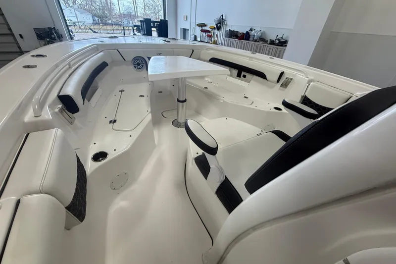 Slide: The Image of 2022 Tidewater 272 CC Adventure boat interior with seating and table setup. - 13