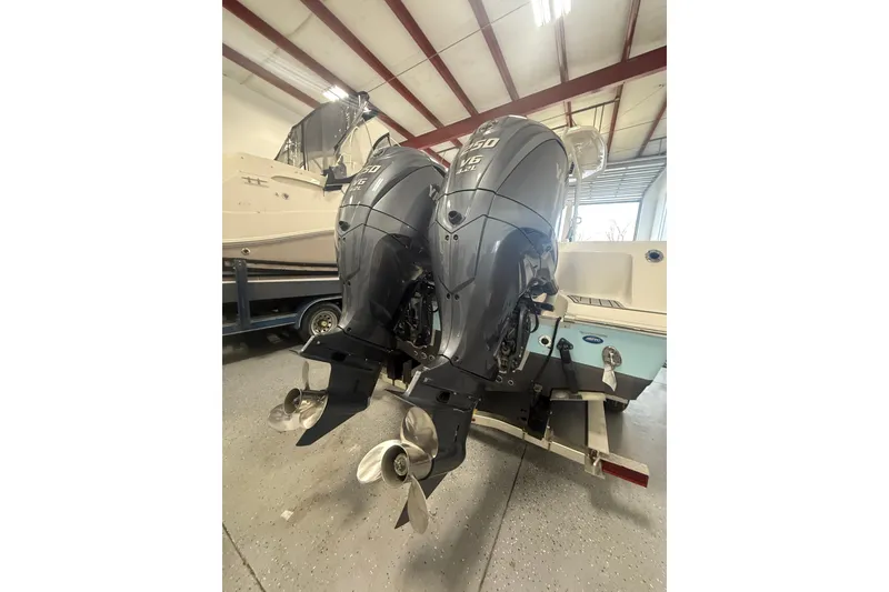 Slide: The Image of 2022 Tidewater 272 CC Adventure boat with dual outboard engines in a garage. - 17