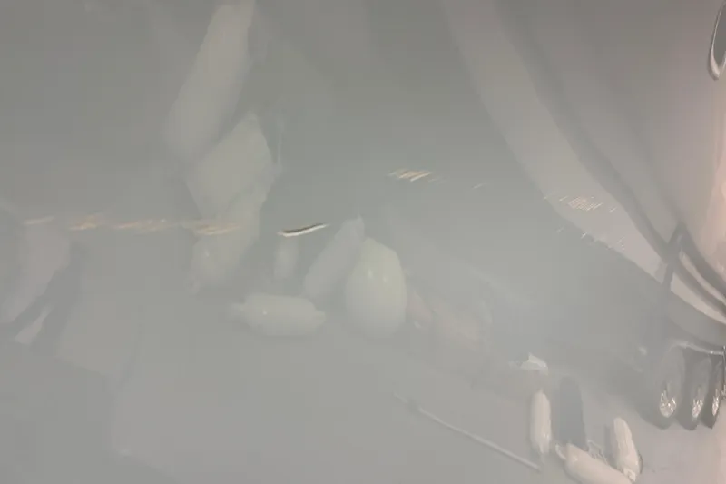 Slide: The Image of 2022 Tidewater 272 CC Adventure boat with visible hull reflection and fenders. - 20