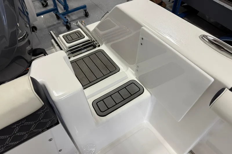 Slide: The Image of 2022 Tidewater 272 CC Adventure boat deck with foldable ladder and cushioned seating. - 7