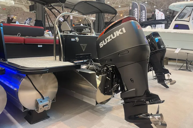 Slide: The Image of 2024 Tahoe Pontoon Cascade Versatile Rear Bench with Suzuki outboard motor at a boat show. - 12