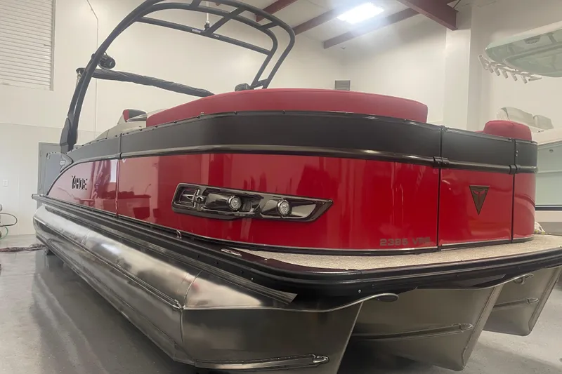 Slide: The Image of 2024 Tahoe Pontoon Cascade Versatile Rear Bench in showroom, featuring sleek red and black design. - 14
