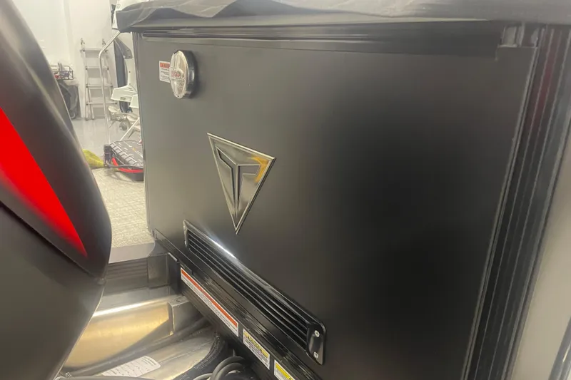 Slide: The Image of 2024 Tahoe Pontoon Cascade Versatile Rear Bench, black panel with logo in a workshop setting. - 19