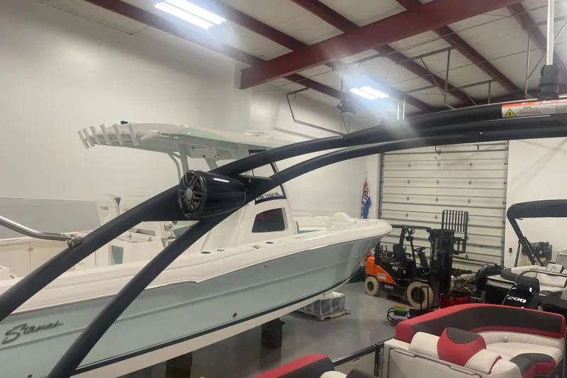 Slide: The Image of 2024 Tahoe Pontoon Cascade Versatile Rear Bench in a showroom with other boats. - 24