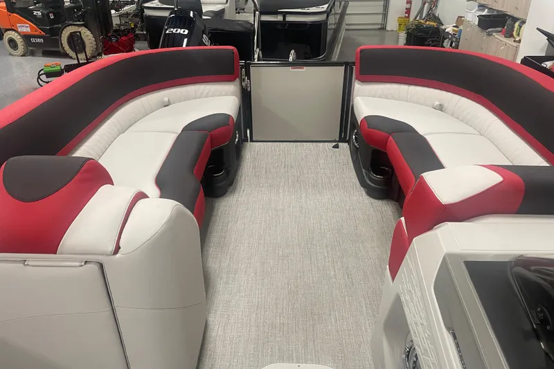 Slide: The Image of 2024 Tahoe Pontoon Cascade Versatile Rear Bench with red and gray seating in a showroom. - 30