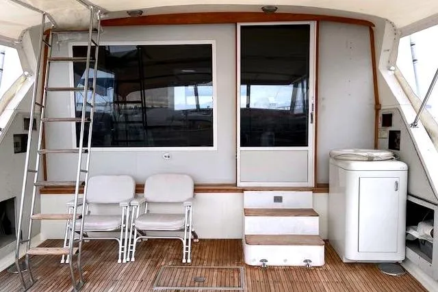 Slide: The Image of 1984 Bertram 54 Convertible yacht deck with chairs and ladder. - 2
