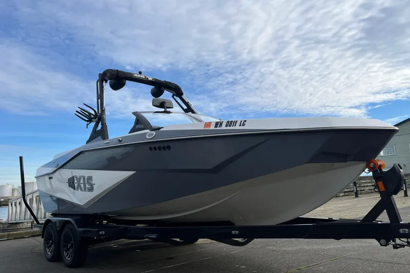 Slide: The Image of 2024 Axis T220 boat on trailer under a partly cloudy sky. - 19