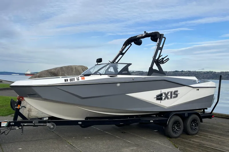 Slide: The Image of 2024 Axis T220 boat on trailer by waterfront, showcasing sleek design and modern features. - 23