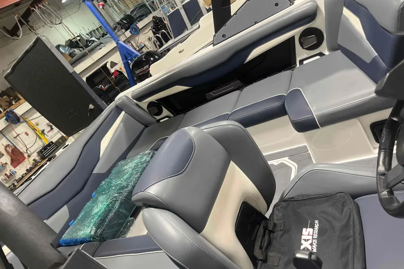Slide: The Image of 2024 Axis T220 boat interior with sleek gray and blue seating in a workshop setting. - 31