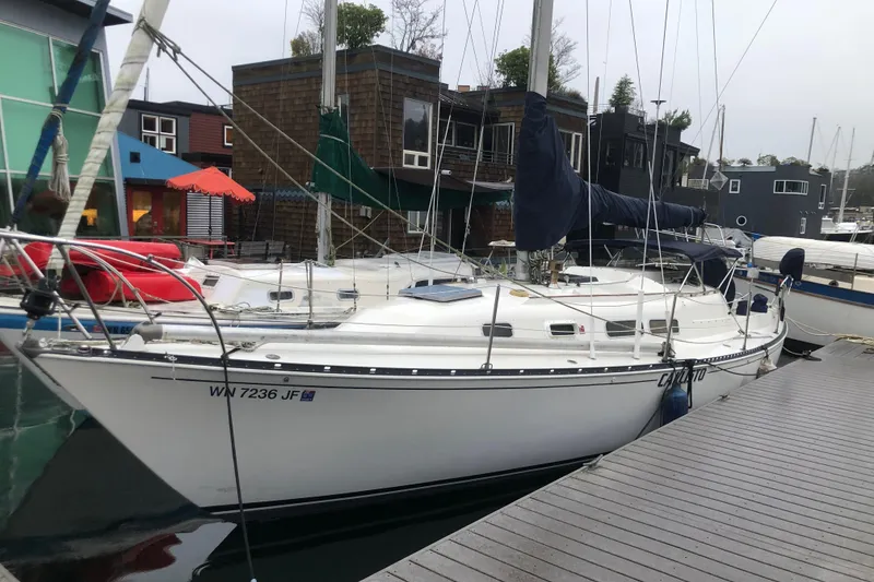The Image of 1972 C&C 35 MKI sailboat docked at a marina with colorful surroundings. - 0