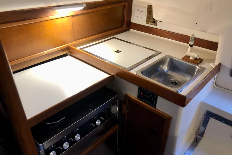 Slide: The Image of 1972 C&C 35 MKI yacht galley with stove, sink, and wooden cabinetry. - 7