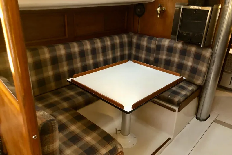 Slide: The Image of 1972 C&C 35 MKI sailboat interior with plaid seating and a central table. - 9