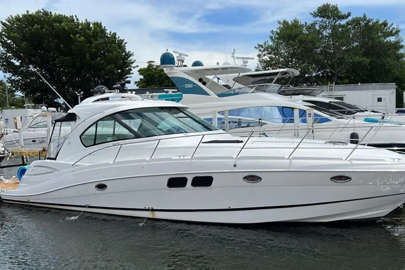 Slide: The Image of 2009 Four Winns V458 yacht docked in marina, sleek white design, calm water. - 10