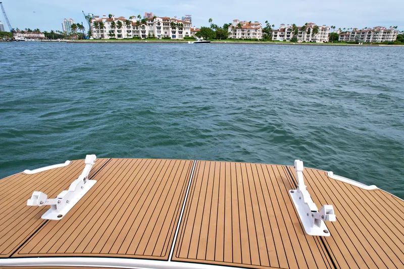 Slide: The Image of 2009 Four Winns V458 boat deck overlooking calm waters and distant buildings. - 13