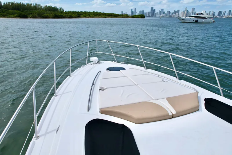 Slide: The Image of 2009 Four Winns V458 yacht cruising near city skyline and lush greenery. - 14