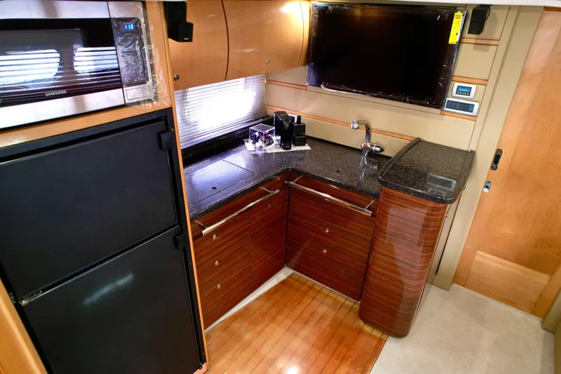 Slide: The Image of 2009 Four Winns V458 yacht kitchen with modern appliances and sleek wooden cabinetry. - 24