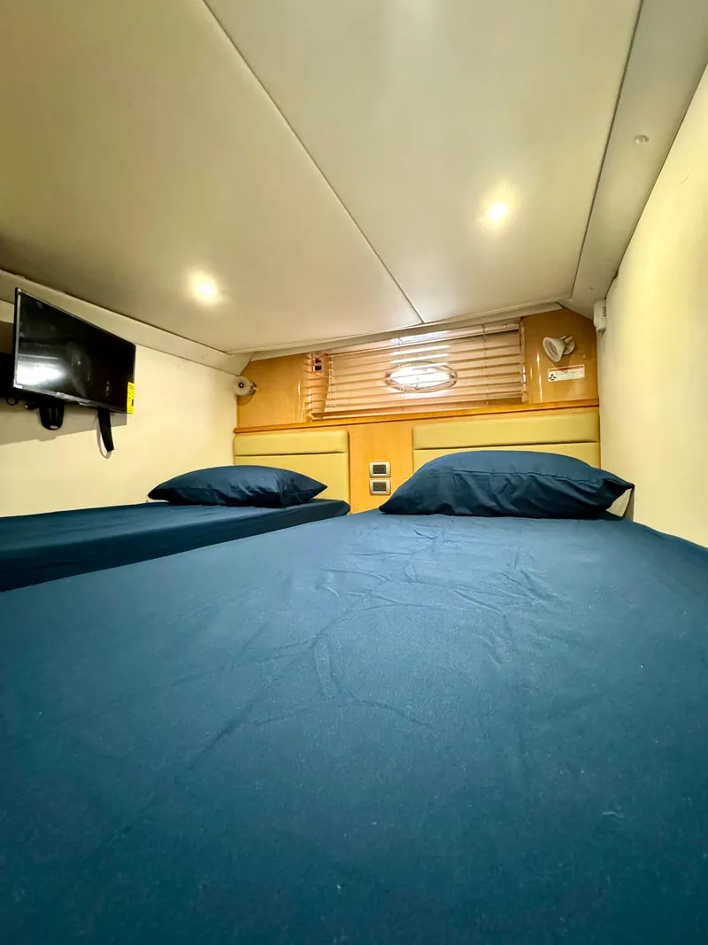 Slide: The Image of 2009 Four Winns V458 cabin interior with bed, TV, and ambient lighting. - 25