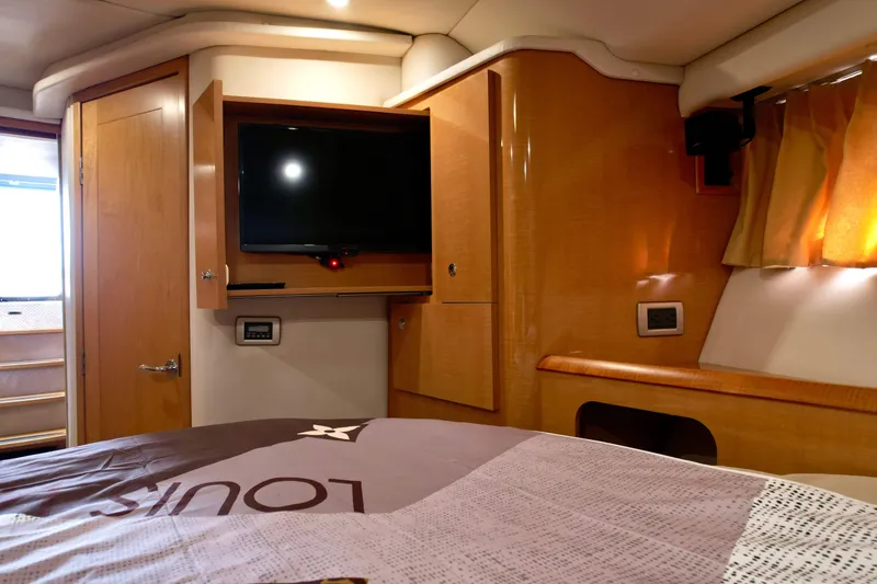 Slide: The Image of Interior of 2009 Four Winns V458 yacht cabin with TV and wooden cabinetry. - 28