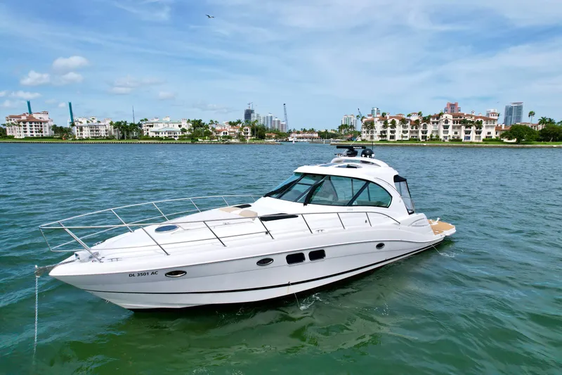 Slide: The Image of 2009 Four Winns V458 yacht cruising on a sunny day near coastal buildings. - 3