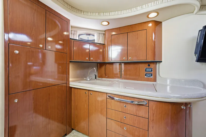 Slide: The Image of Luxurious 2002 Sea Ray 460 Sundancer yacht kitchen with sleek wood cabinetry and modern fixtures. - 14