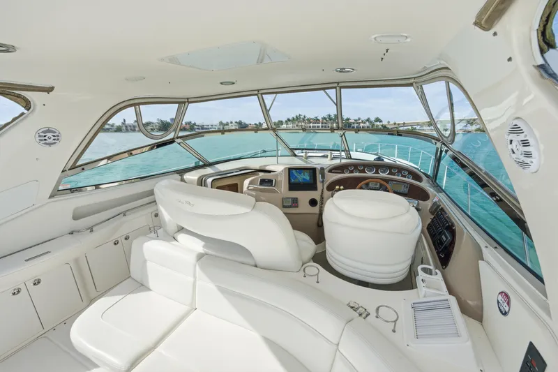 Slide: The Image of Luxurious 2002 Sea Ray 460 Sundancer yacht interior with helm and seating, overlooking turquoise waters. - 26