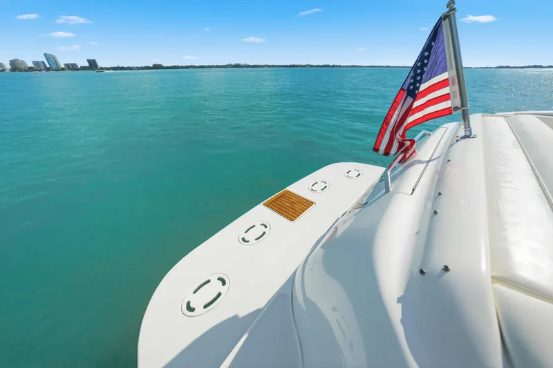 Slide: The Image of 2002 Sea Ray 460 Sundancer yacht with American flag on calm blue water. - 3
