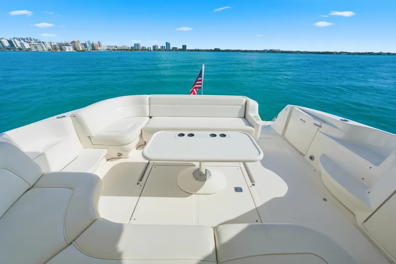 Slide: The Image of 2002 Sea Ray 460 Sundancer yacht deck with seating, table, and ocean view. - 30